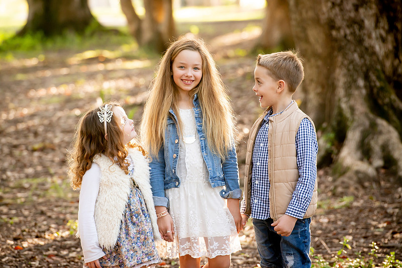 Three siblings outdoors at golden hour